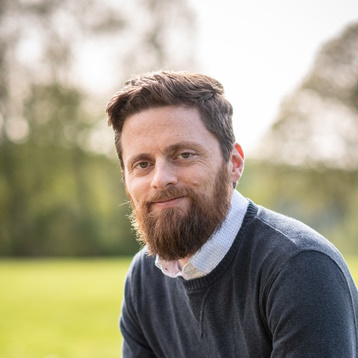 Headshot of Jonathon Webster, a white man with brown hair and a full beard.