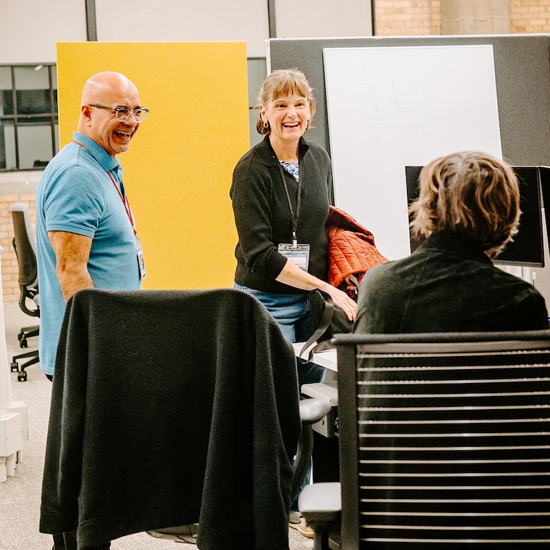 Two nonprofit leaders chat with their team, smiling
