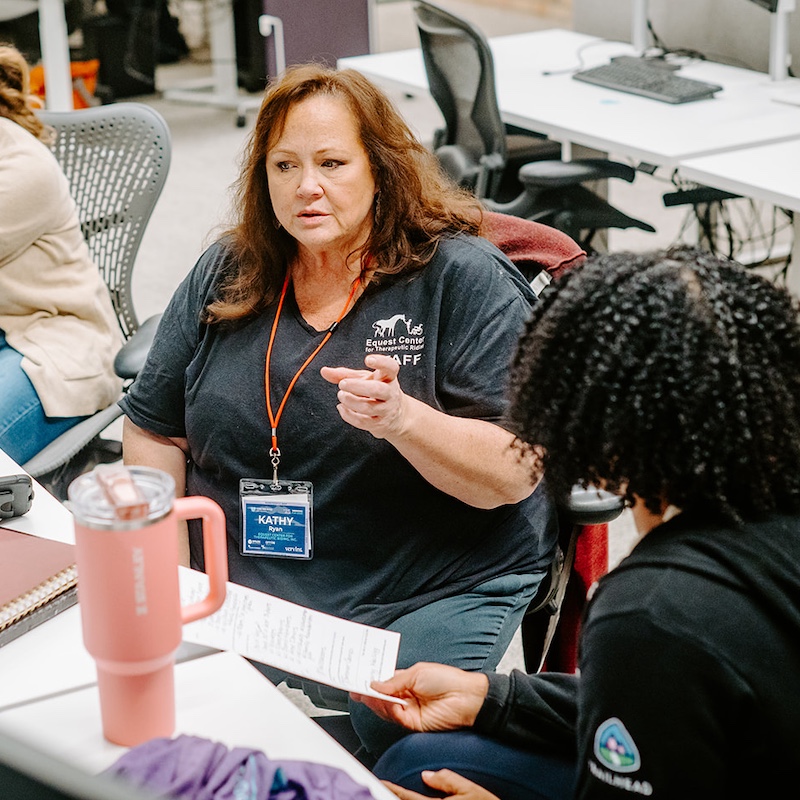 A nonprofit representative and volunteer discuss project requirements